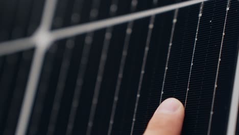 dedo de la persona que toca la celda del panel solar en una vista macro cercana