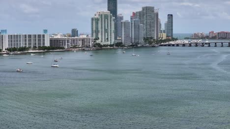 Aerial-tilt-up-shot-of-jet-ski-cruising-on-water-of-Venetian-Islands-in-Miami-City