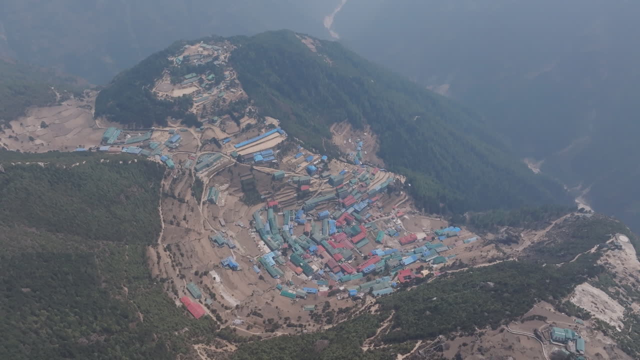 Aerial shot of Namche Bazar, Himalayan village nestled in lush green hills and forests on the way to Mount Everest in Sagarmatha National Park, Nepal