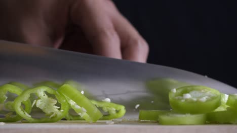 chef slices green chilli for cooking