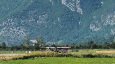 small airplane landing on a grassy field