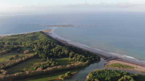 Vista-Superior-De-Drones-De-Costa-Rica-Que-Muestra-El-Mar,-La-Costa-Y-El-Bosque-De-Palmeras-En-El-Océano-Pacífico-Con-Una-Playa-En-Forma-De-Cuento-De-Ballena