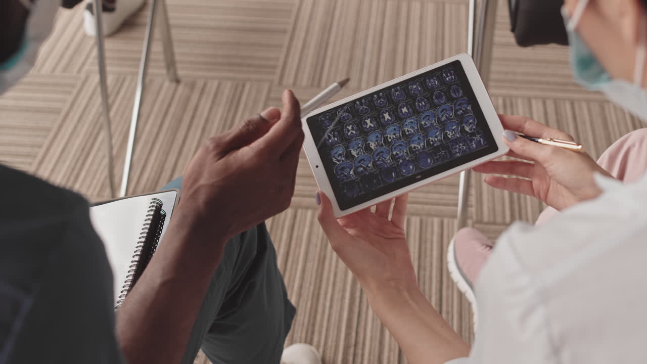 Doctors review brain scan on tablet