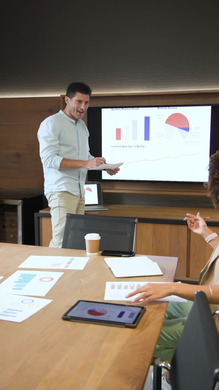 Ricezione di report stampati, diversi colleghi che discutono di dati e indicano grafici nella sala riunioni