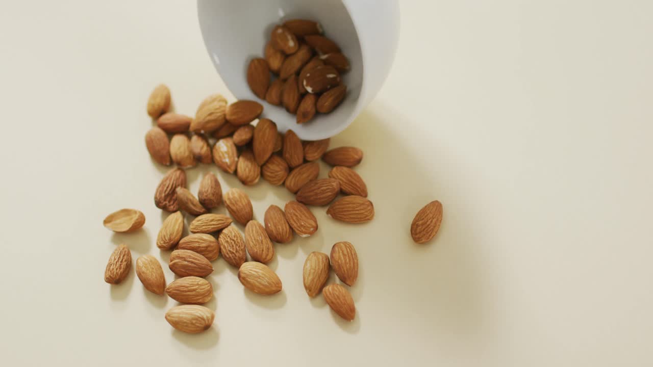Video of almonds in a bowl on white background