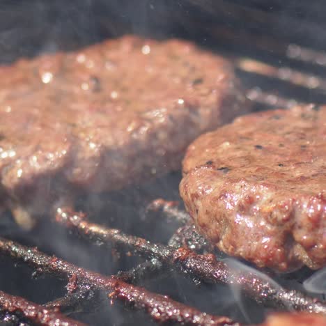 Leckeres-Zwei-Hamburger-Fleisch-Braten-Auf-Rauchen-Heißem-Grill-slow-motion-video