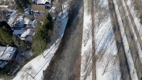 Luftaufnahme-Von-Menschen,-Die-Auf-Einem-Zugefrorenen-Fluss-In-Einer-Kleinen-Holländischen-Stadt-In-Den-Niederlanden-Eislaufen