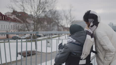 rear view of muslim woman and her disable friend looking at something in the sky in city in winter