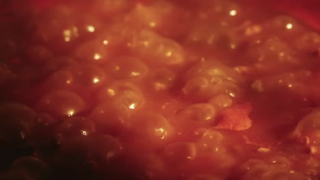 close-up view of a simmering, bubbly tomato sauce