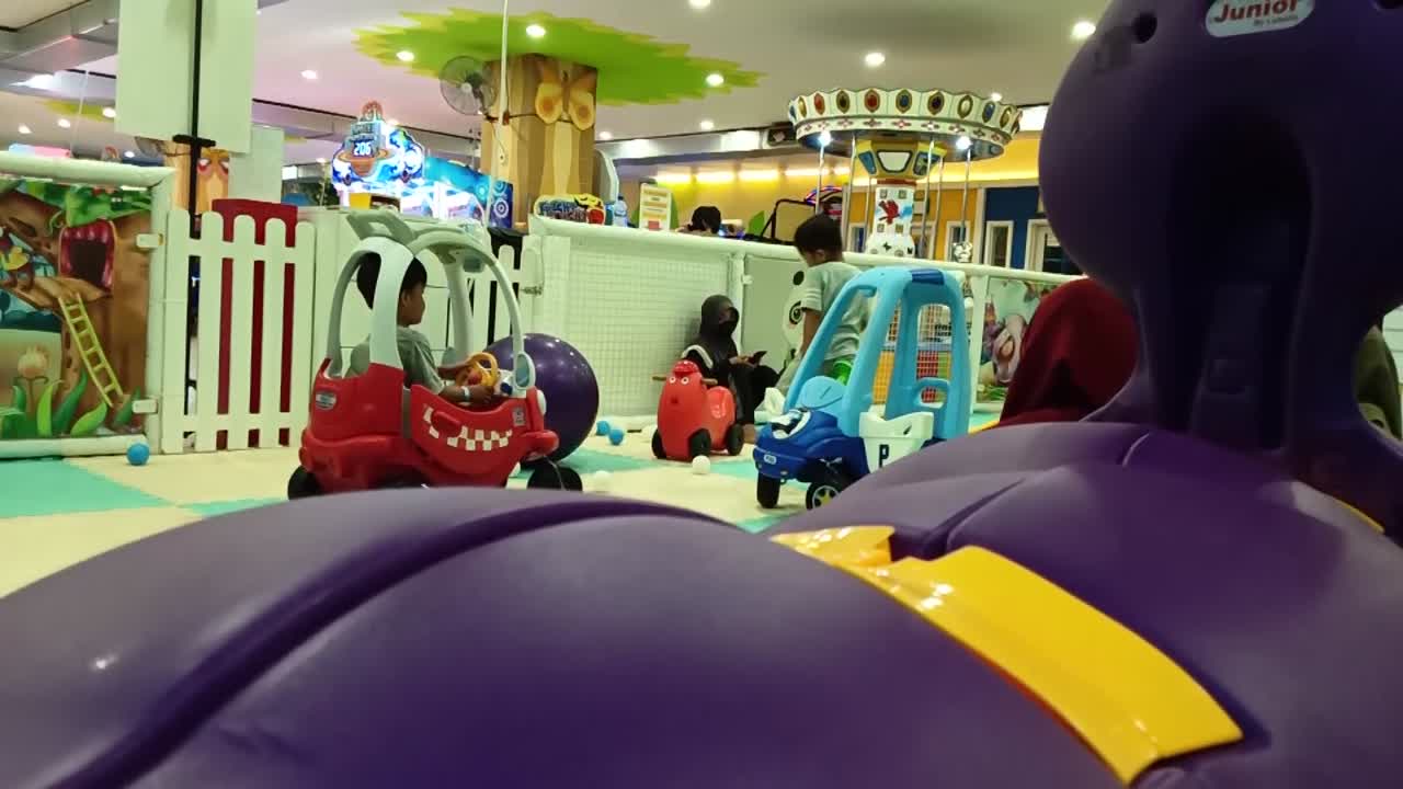 Toddlers playing in a colorful indoor playground at a shopping mall