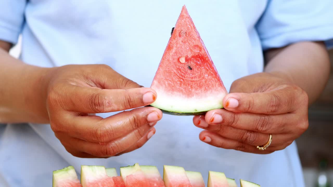 mujer sosteniendo una rebanada de sandía