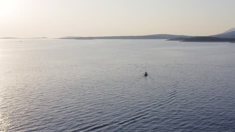 Amazing-aerial-landscape-view-over-sailboat-travelling-through-ocean-at-sunset