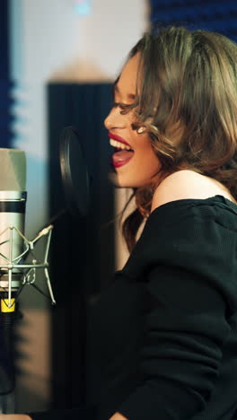 girl singing to the microphone in a studio. female vocal. vertical video