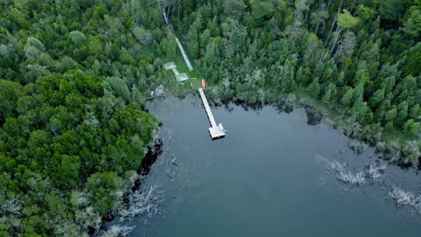 Luftumlaufbahn-Eines-In-Einem-Wald-Versteckten-Docks-Mit-Kristallklarem-Wasser,-Das-Es-Ermöglicht,-Die-Bäume-Darin-Zu-Sehen---Drohnenaufnahme