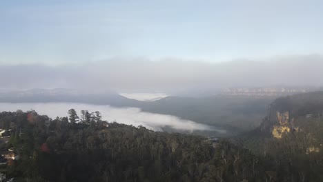 Eine-Drohnenluftaufnahme-Bewegt-Sich-Rückwärts-Von-Den-Blue-Mountains,-Um-Die-Stadt-Katoomba-An-Einem-Bewölkten-Tag-Freizugeben