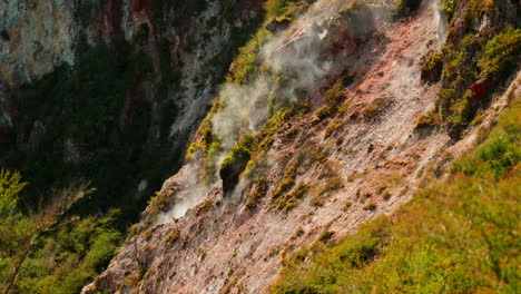 Steam-coming-off-rainbow-mountain,-Rotorua,-New-Zealand