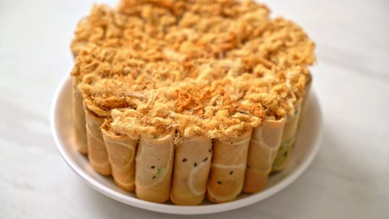 Rollo de coco crujiente con carne de cerdo desmenuzada seca en la placa