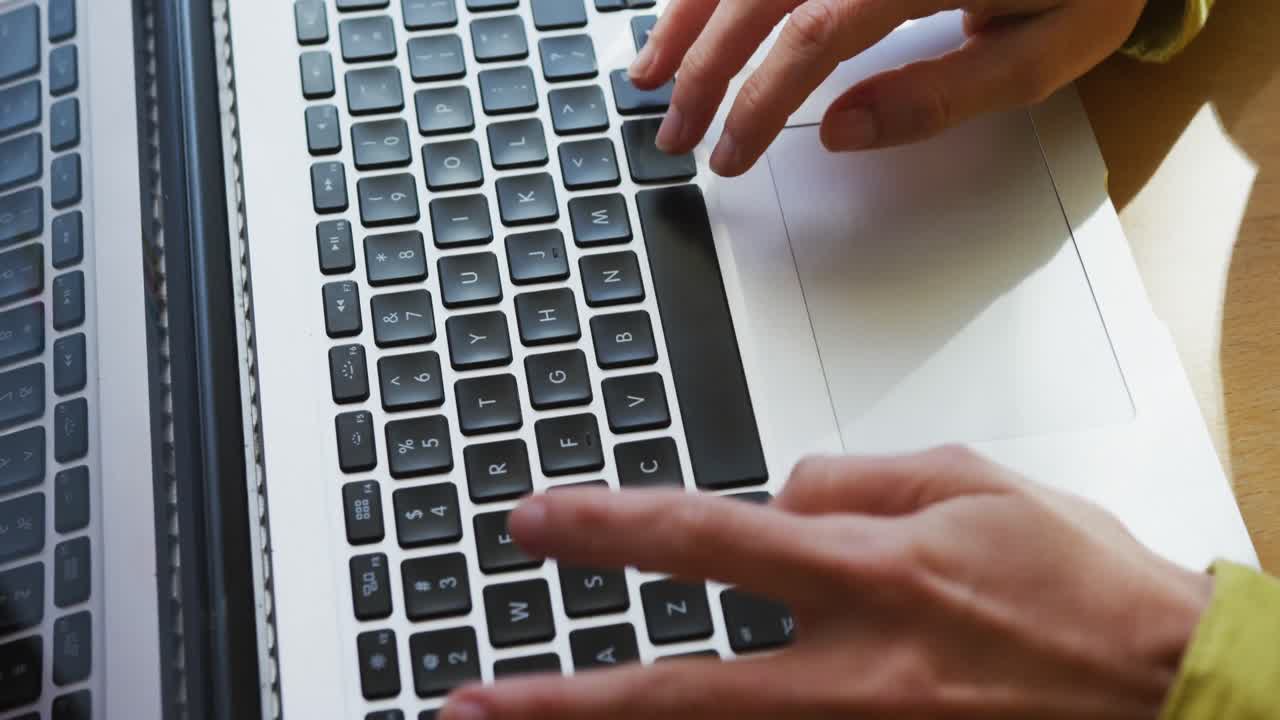 sección media de una mujer caucásica usando una computadora portátil y trabajando desde casa