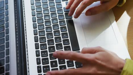 sección media de una mujer caucásica usando una computadora portátil y trabajando desde casa