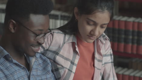 pretty girl and handsome black boy studying in the library 3