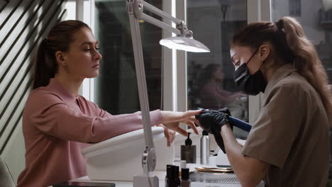 woman getting a manicure at a nail salon