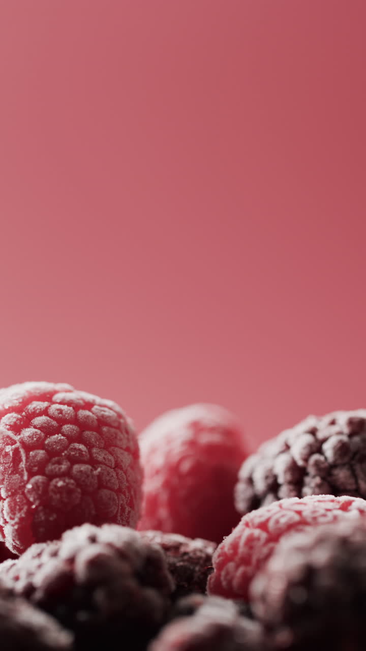 Micro vertical video close up of raspberries and copy space on red background