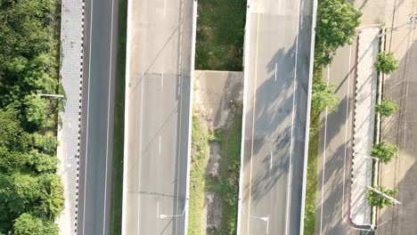 drone flying out for top aerial view following a car on railway crossing bridge in the countryside khonkaen, thailand