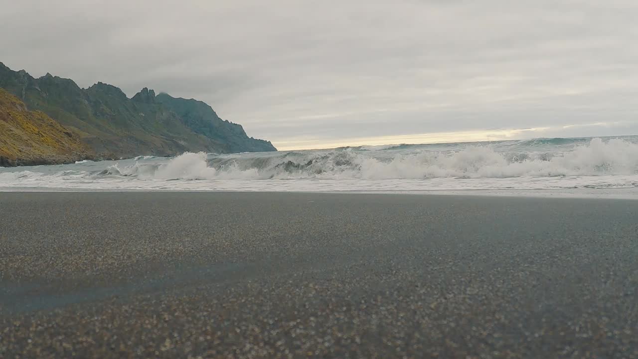 Scenic Beach with Waves and Mountains