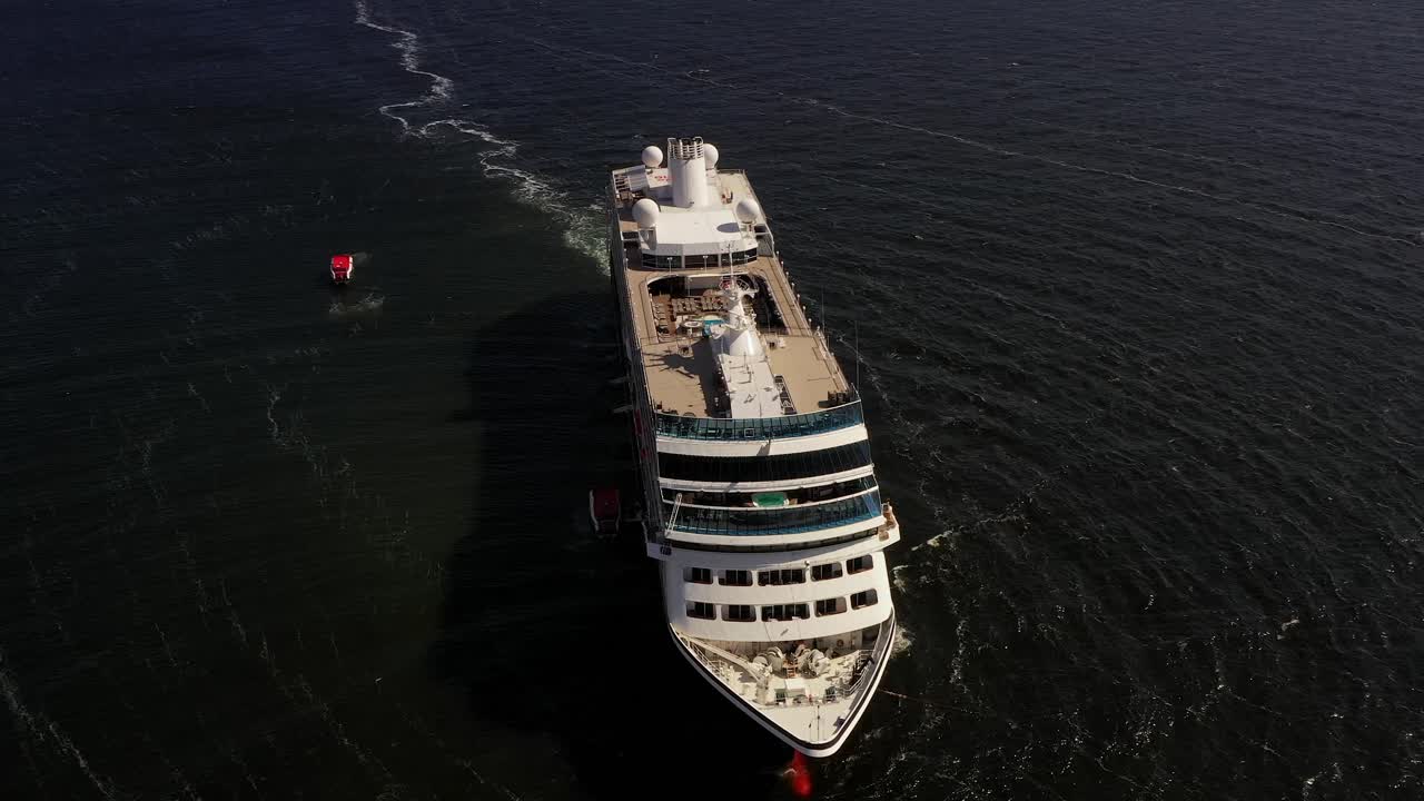 Aerial front view of the Azamara cruise ship alongside a small day trip boat