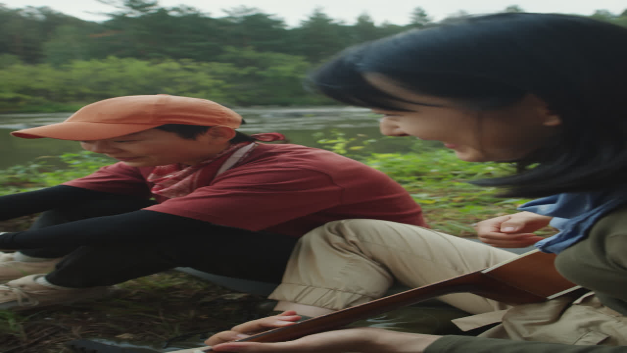 Girlfriends Playing Guitar and Laughing by Campfire