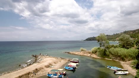 aerial view of small natural harbor in the area of agia paraskevi halkidiki, greece, move forward by drone