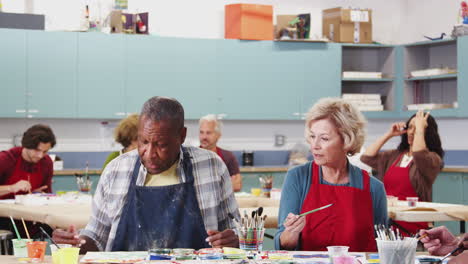 Group-Of-Retired-Seniors-Attending-Art-Class-In-Community-Centre-With-Teacher