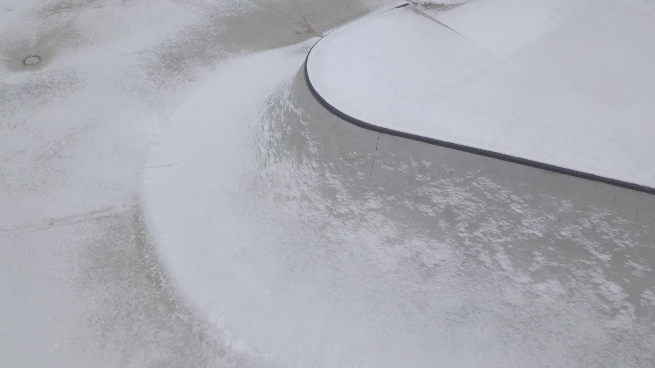 parte de un skatepark de hormigón cubierto de nieve ligera