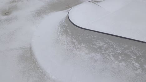 part of a concrete skatepark covered with light snow