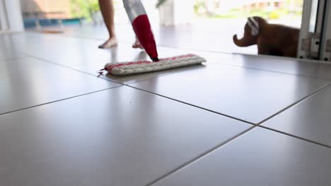 woman mopping a tile floor with a vacuum mop