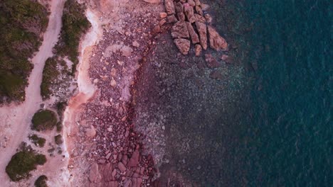 Statische-Overhead-Luftaufnahme-Von-Oben-Nach-Unten-Von-Verträumtem-Felsigem-Strandhintergrund,-Sonnenuntergang