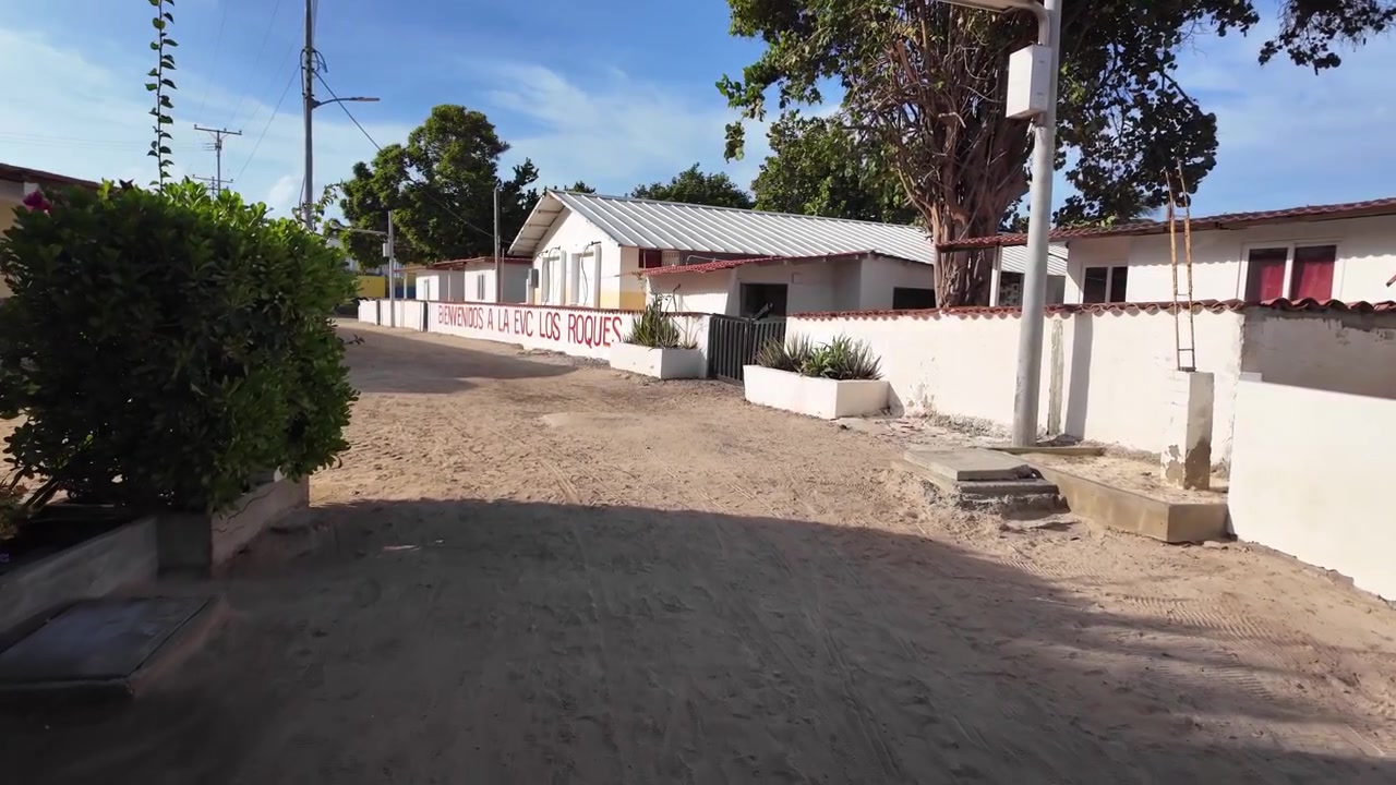 Ripresa POV a mano libera che esplora un sentiero rustico dell'isola a Los Roques, Venezuela, muovendosi verso la stazione di comando locale della Guardia Nazionale