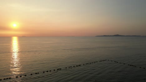 Beautiful-golden-sunset-reflected-on-surface-of-calm-sea-with-islands-in-distance