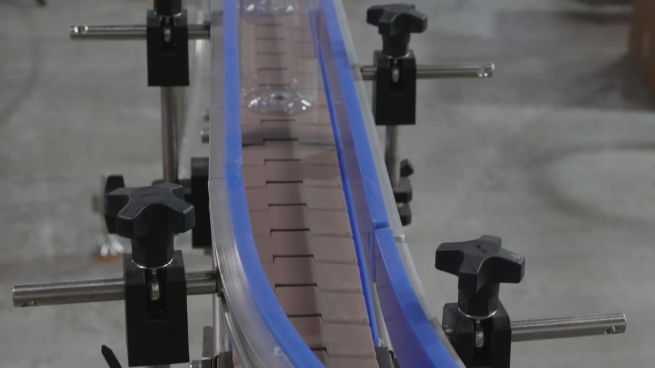 성형된 플라스틱 페트병이 컨베이어 벨트에서 움직이고 있습니다.