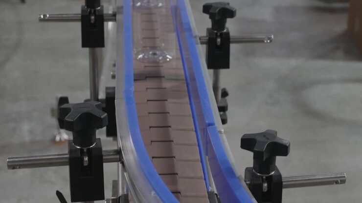 Moulded plastic PET bottles are moving on a conveyor belt
