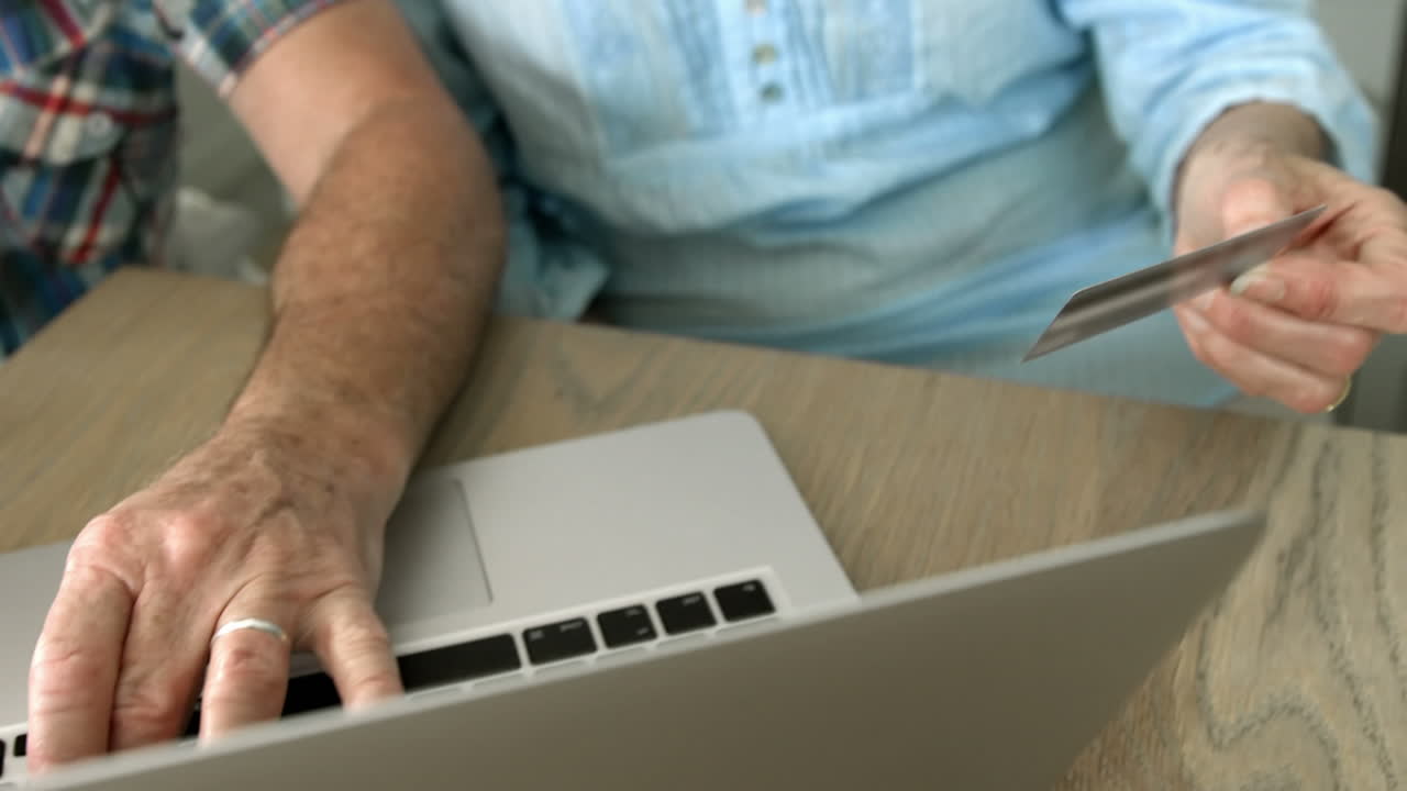 una pareja de ancianos pagando en internet.