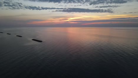 Lago-Erie-Puesta-De-Sol-En-Erie,-Pennsylvania-Con-Tiro-De-Drone-Moviéndose-Hacia-Abajo-Sobre-El-Agua