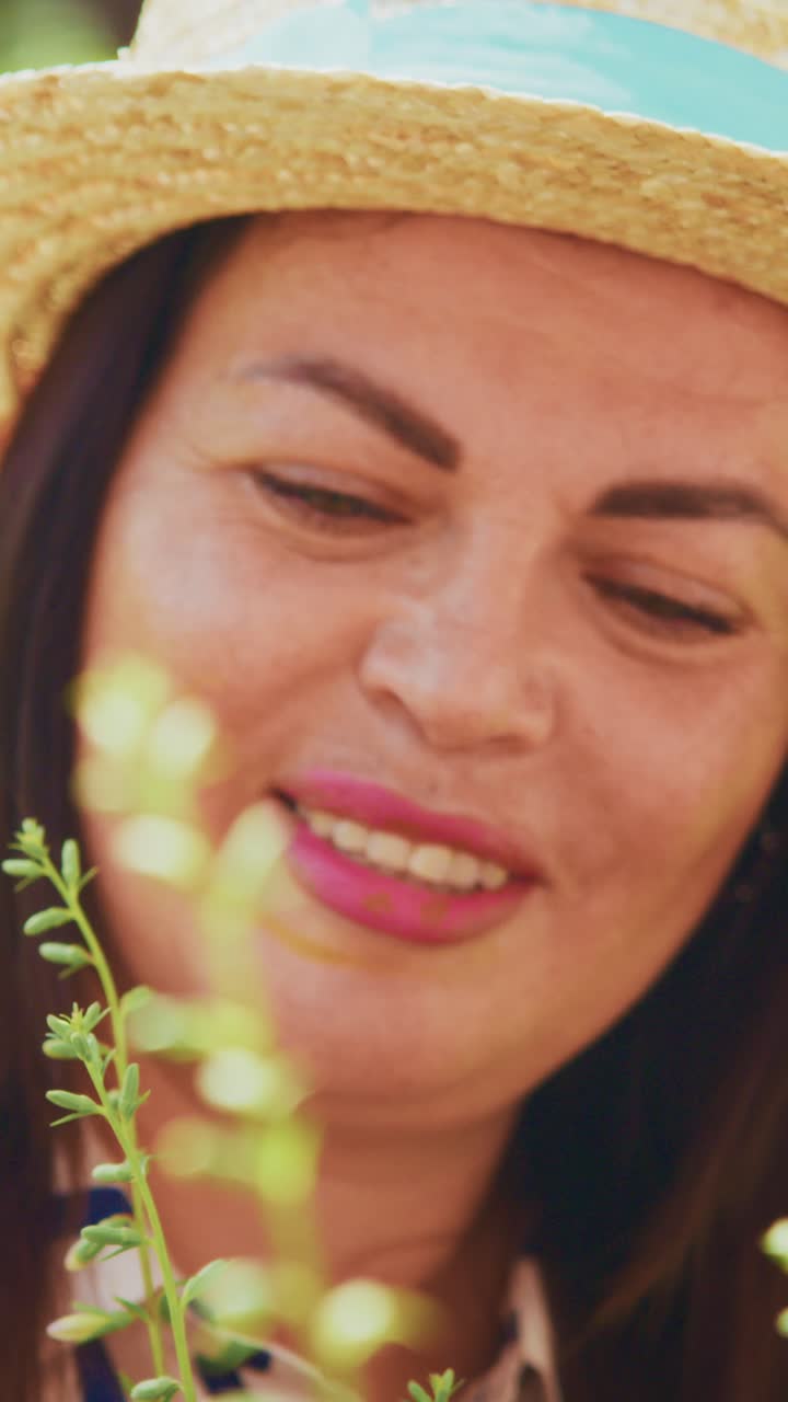 A Joyful Woman Wearing a Straw Hat Smiles Brightly Amidst a Colorful Garden, Radiating Happiness and Connection with Nature in a Serene Setting