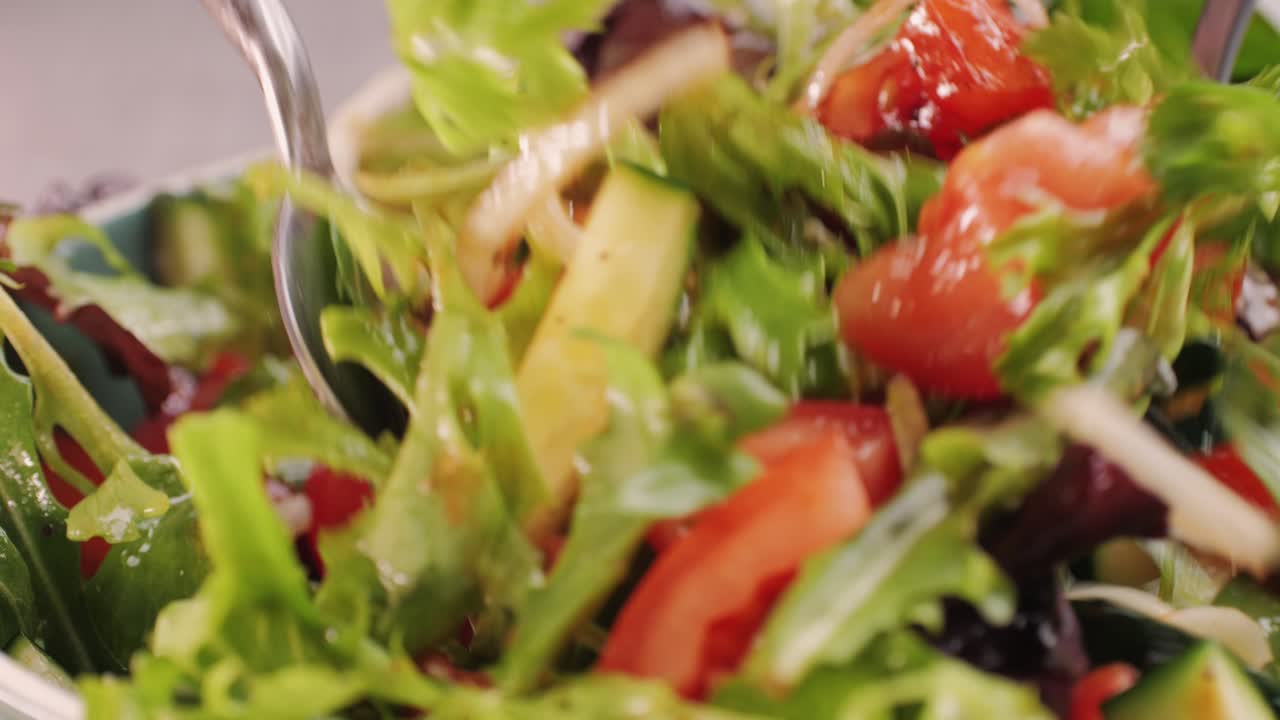 Mixing a fresh salad in a bowl