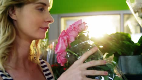hermosa florista mujer que huele a un ramo de rosa rosa