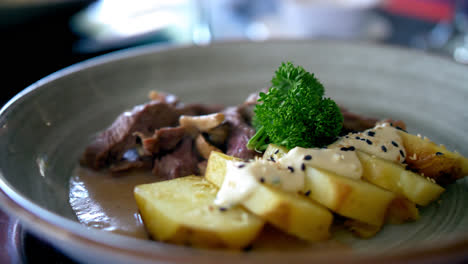 Plate-of-sirloin-steak-with-potato-and-red-wine-pepper-sauce,-close-up