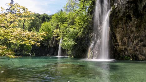 Una-Hermosa-Cascada-Cae-Sobre-Un-Lago-Verde,-Tiro-Ancho-Estático