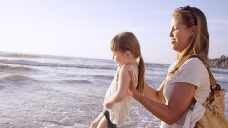 Familia-Feliz-Jugando-En-Las-Olas-En-La-Playa-Al-Atardecer-De-Vacaciones