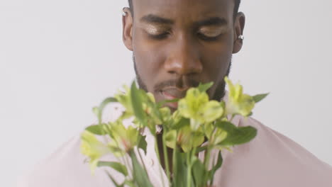 handsome guy holding and smelling the aroma of the flowers