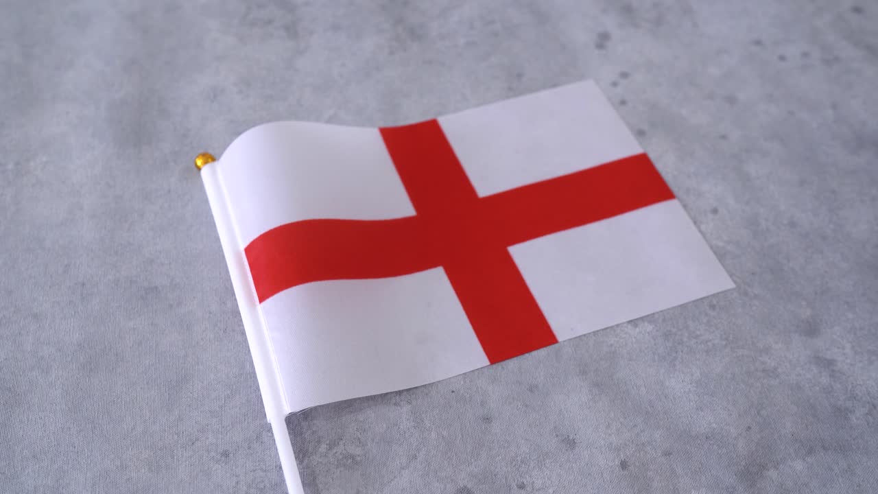 Bandiera dell'Inghilterra in primo piano su sfondo grigio. Bandiera nazionale inglese.